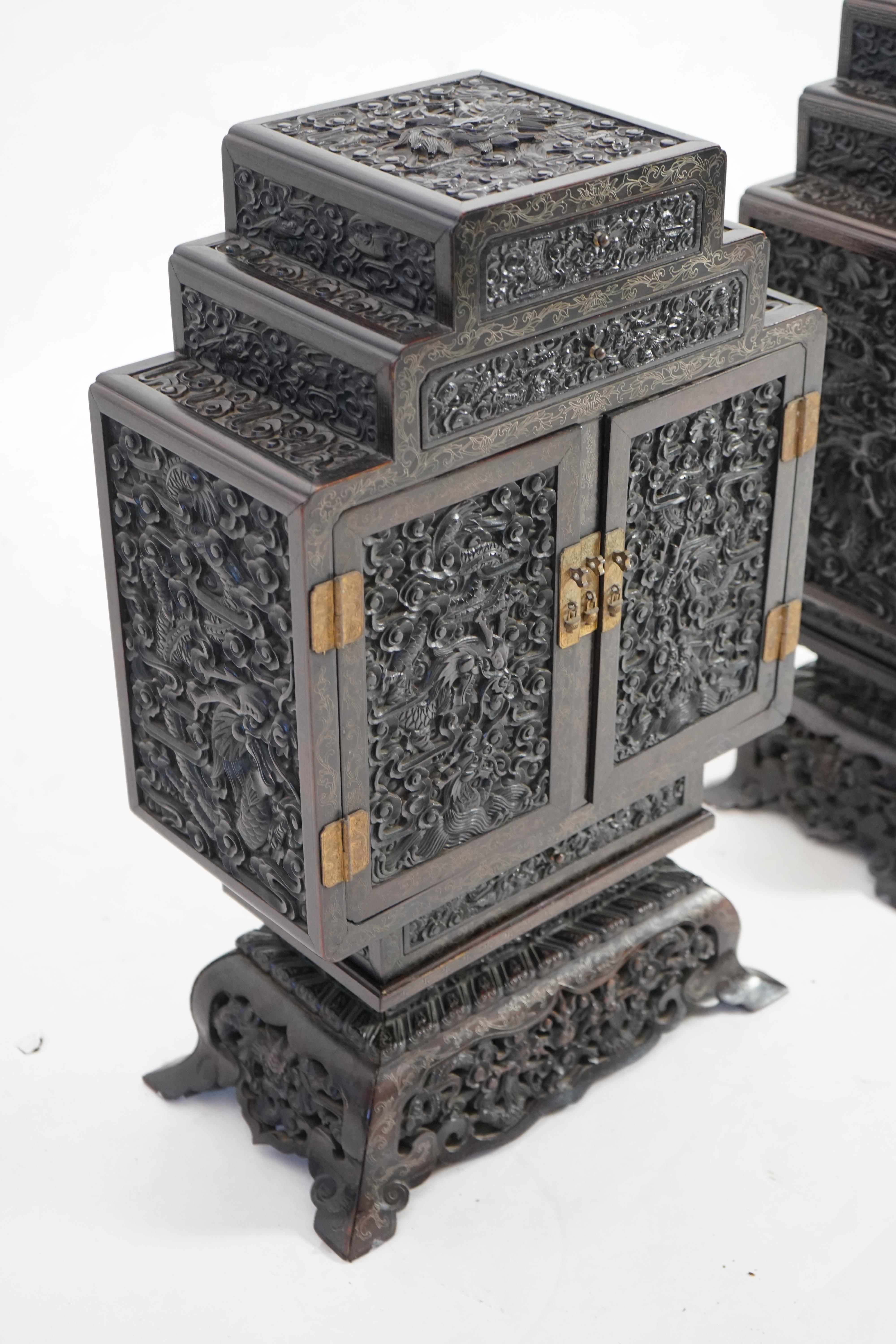 An important pair of Chinese carved zitan and silver wire inlaid ‘cloud and dragon’ curio cabinets and stands, duobaoge, probably Imperial, late Qing dynasty
